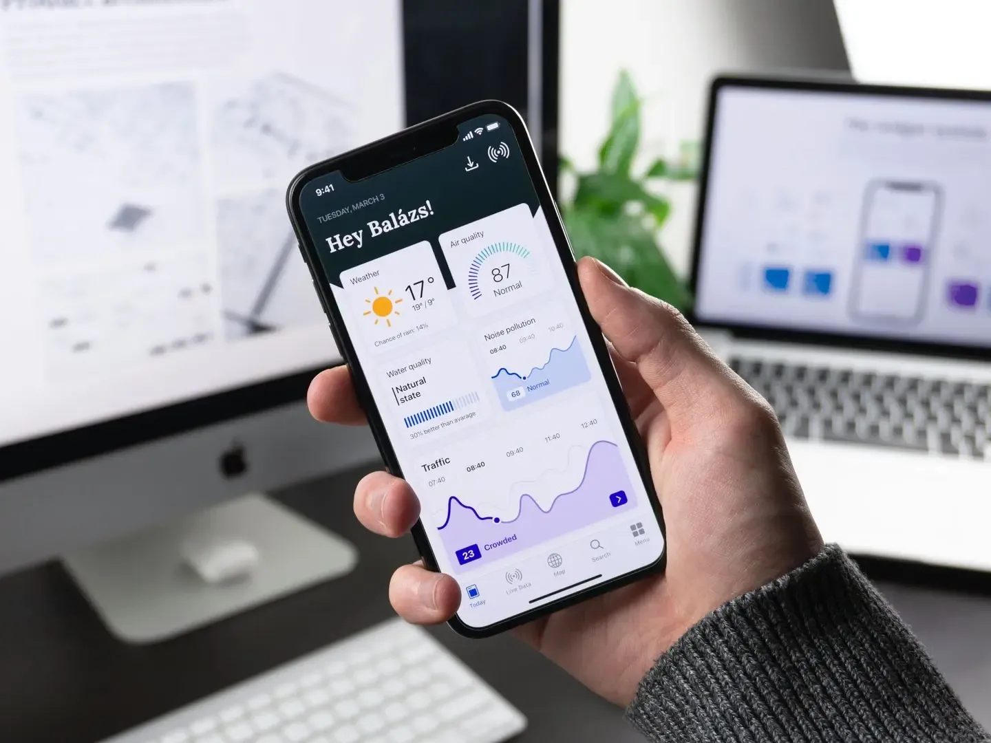 Mano sosteniendo un teléfono con una app de panel de datos